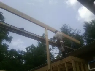 Carpenter setting a ridge beam over a new addition frame — Ice Dam Removal by Roofing Brothers in Laguna Niguel